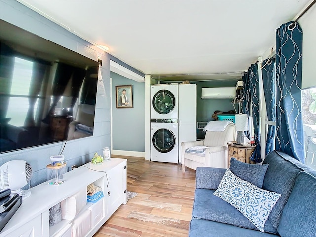 living room featuring stacked washer / drying machine, light wood-style flooring, and a wall unit AC