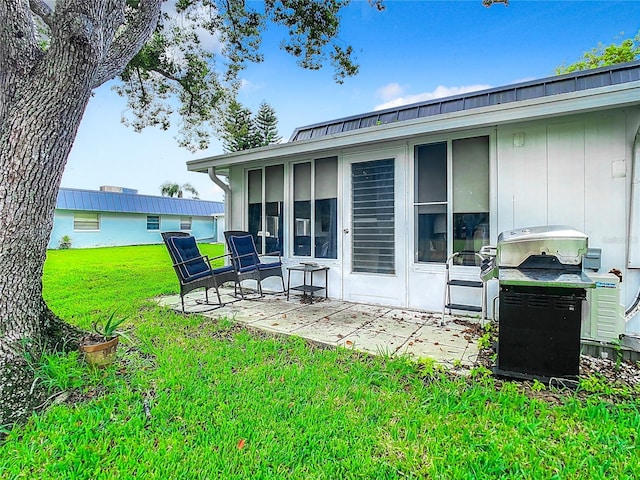 back of house with a patio area, a lawn, and a sunroom