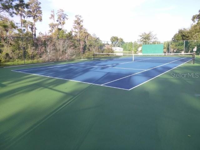 view of tennis court featuring fence and community basketball court