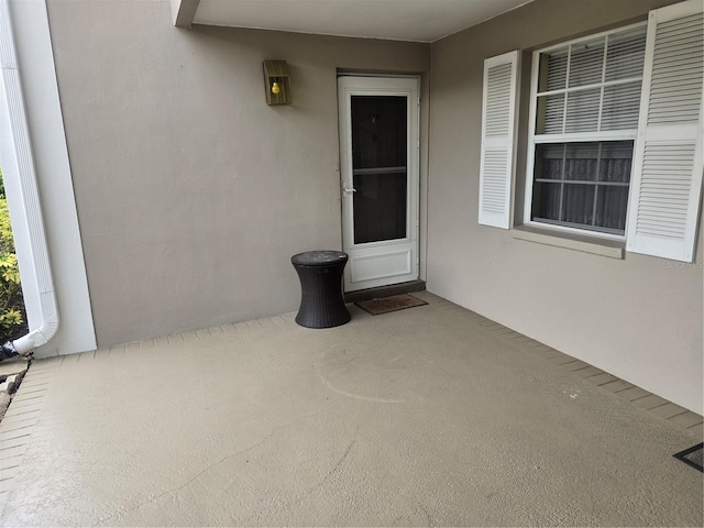 doorway to property featuring a patio and stucco siding