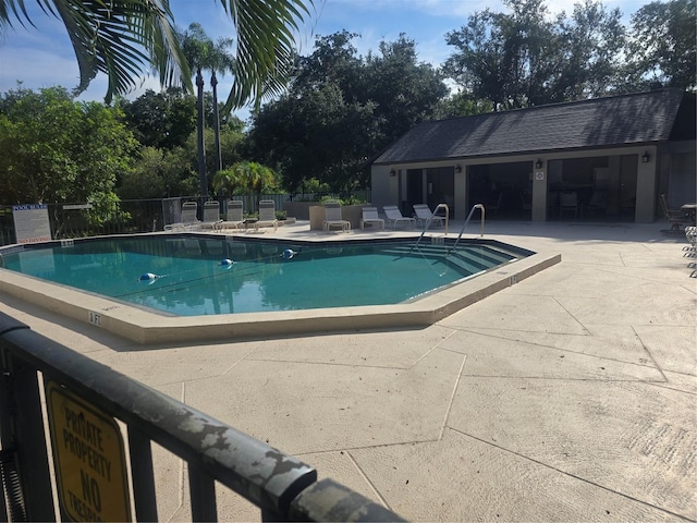 pool with fence and a patio area