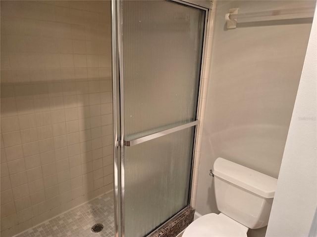 full bathroom featuring a stall shower and toilet
