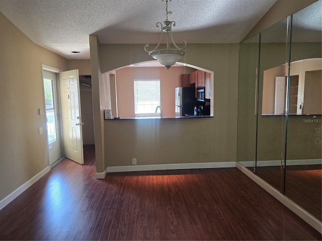 5265 E Bay Dr Unit 420, Clearwater, FL 33764 - kitchen with freestanding refrigerator, dark wood-type flooring, baseboards, a textured ceiling, and black microwave