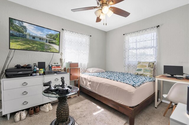 bedroom with carpet floors, multiple windows, and ceiling fan