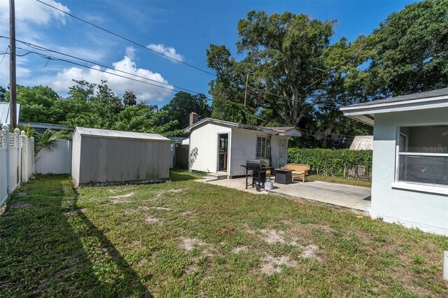 view of yard with a storage shed and a patio