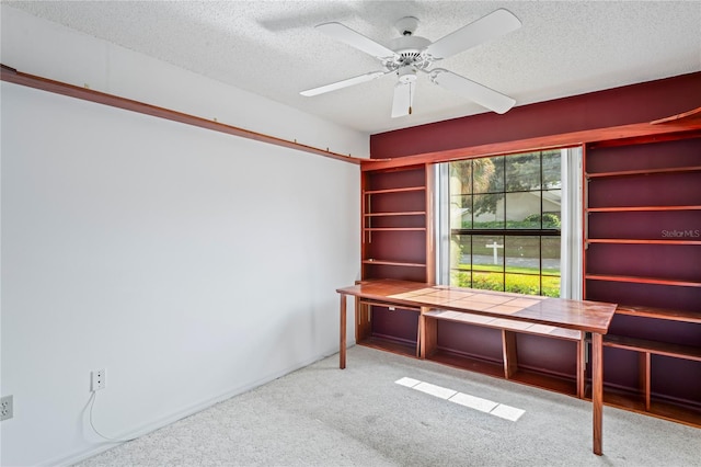 unfurnished office with ceiling fan, a textured ceiling, and light carpet