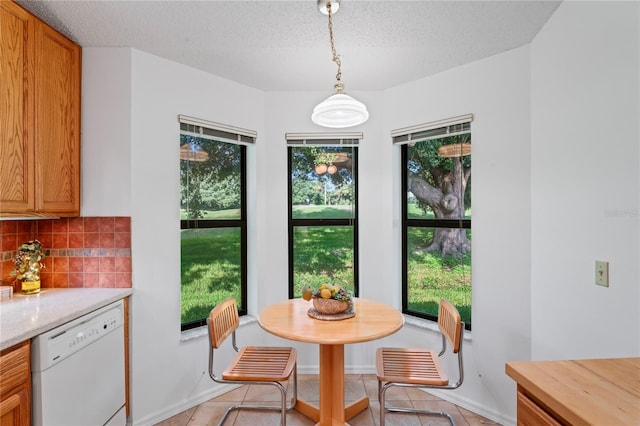 tiled dining room featuring a textured ceiling and plenty of natural light