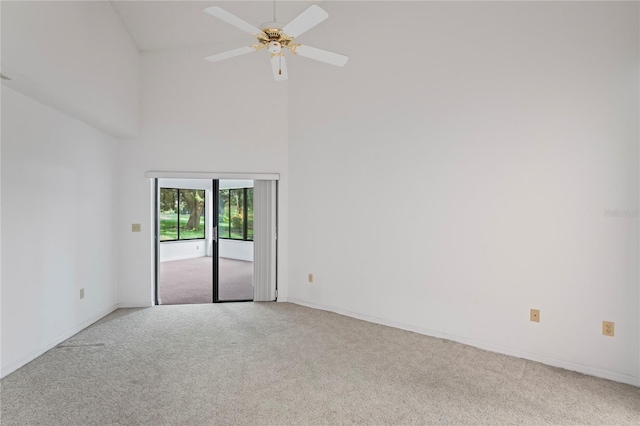 empty room featuring ceiling fan, high vaulted ceiling, and carpet floors