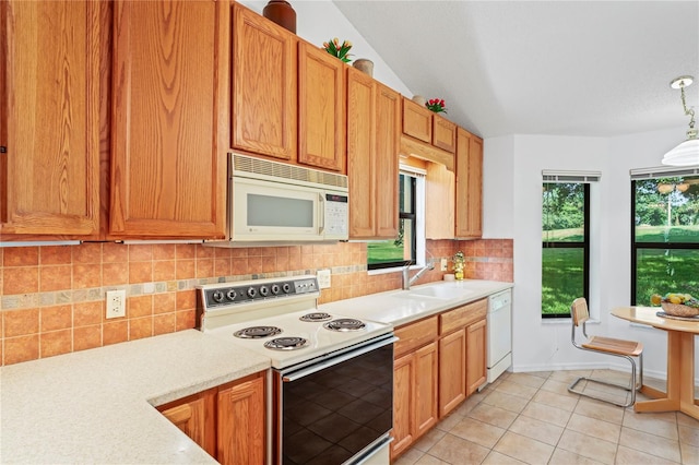 kitchen with lofted ceiling, pendant lighting, white appliances, decorative backsplash, and sink