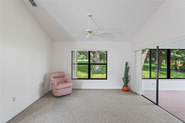 unfurnished room with ceiling fan, a wealth of natural light, vaulted ceiling, and carpet floors