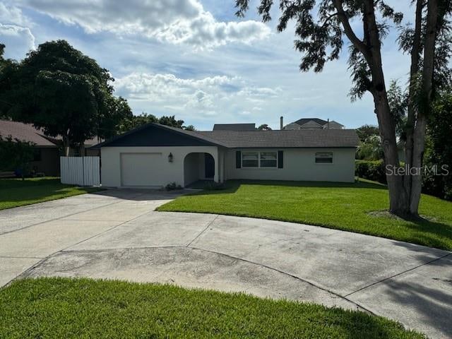 single story home featuring a front lawn and a garage