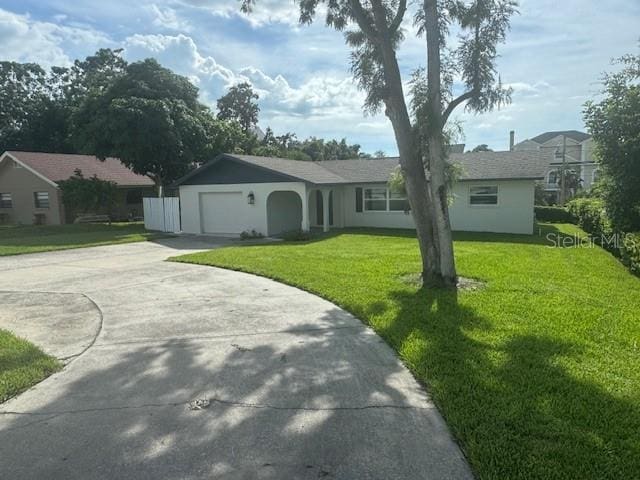 ranch-style home featuring a garage and a front lawn