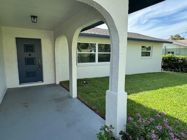 entrance to property featuring a lawn