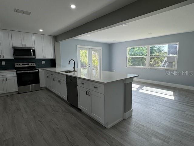 kitchen with a wealth of natural light, kitchen peninsula, sink, and appliances with stainless steel finishes