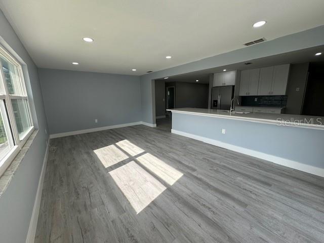 unfurnished living room featuring light hardwood / wood-style floors and sink