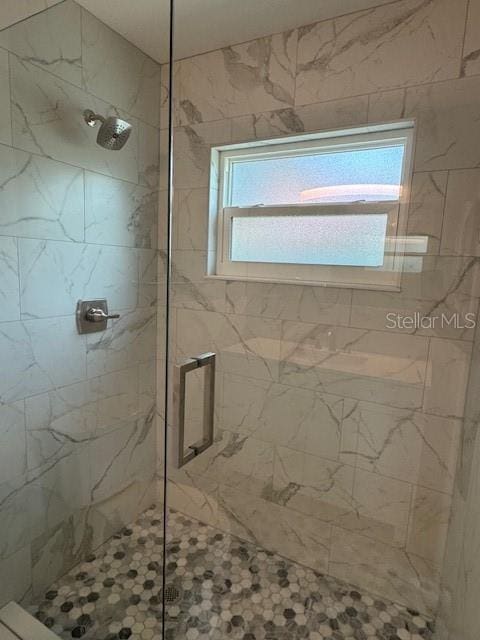 bathroom featuring a shower with door