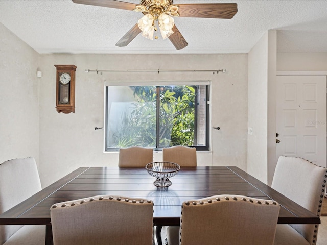 dining area featuring ceiling fan and a textured ceiling