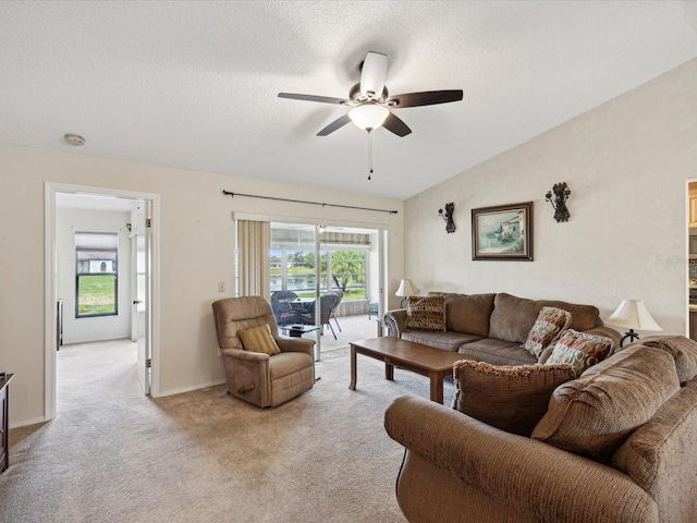 carpeted living room featuring vaulted ceiling, ceiling fan, and a textured ceiling