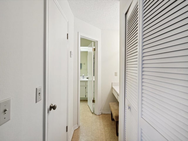 hallway with a textured ceiling