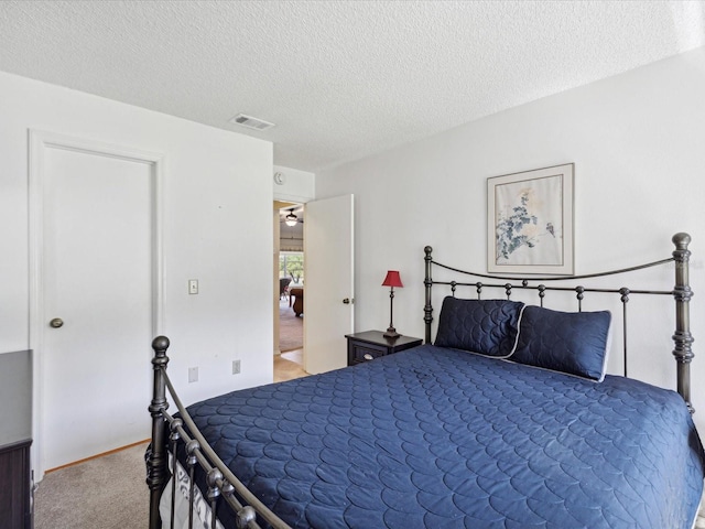 bedroom featuring carpet floors and a textured ceiling