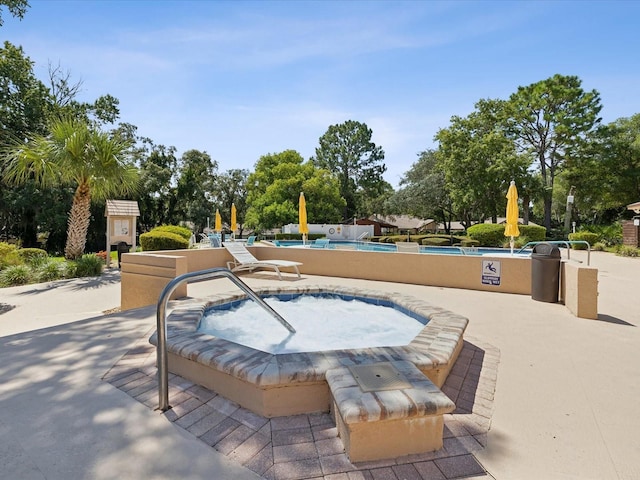 view of home's community with a pool and a patio