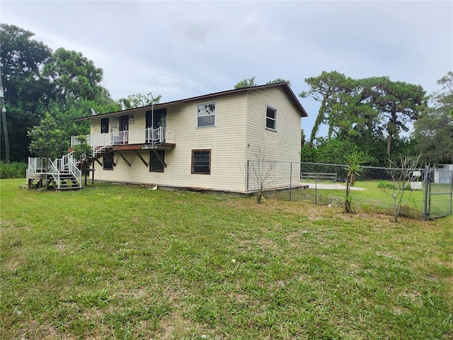 exterior space featuring stairs, a lawn, and fence