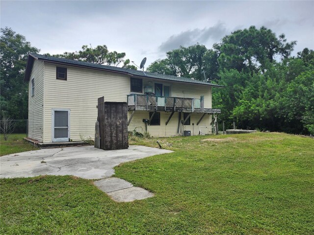 back of property featuring central AC and a yard