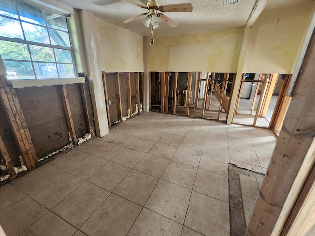 miscellaneous room featuring ceiling fan, a textured ceiling, and tile patterned floors