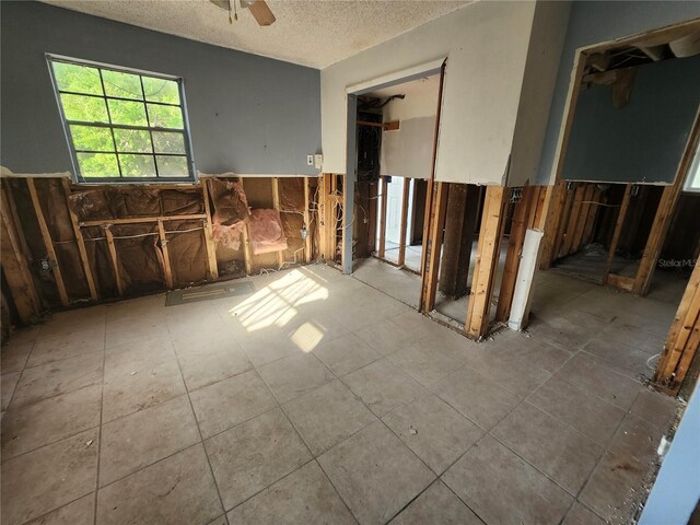 miscellaneous room featuring ceiling fan and a textured ceiling