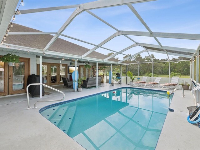 view of swimming pool with area for grilling, french doors, a patio area, and a lanai