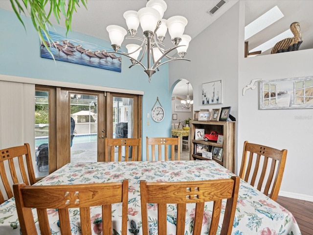 dining room with hardwood / wood-style floors, a notable chandelier, and french doors