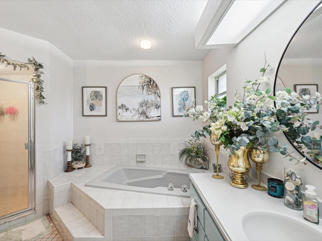 bathroom featuring vanity, plus walk in shower, a textured ceiling, and a skylight