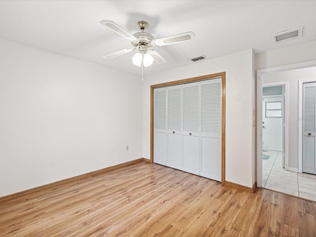 unfurnished bedroom with light hardwood / wood-style floors, a closet, and ceiling fan