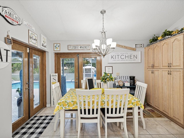 dining room featuring plenty of natural light, lofted ceiling, a chandelier, and french doors