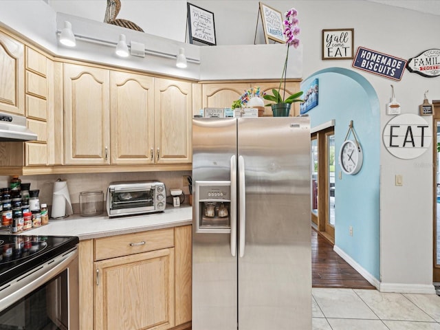 kitchen featuring light brown cabinetry, light tile patterned flooring, and appliances with stainless steel finishes