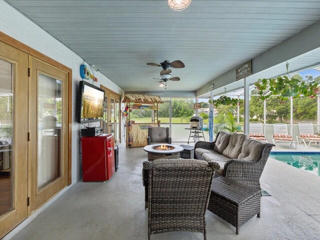 view of patio / terrace with french doors, ceiling fan, and an outdoor living space with a fire pit