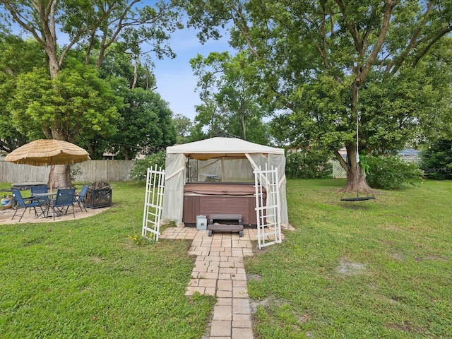 view of yard with a hot tub, a gazebo, and a patio area