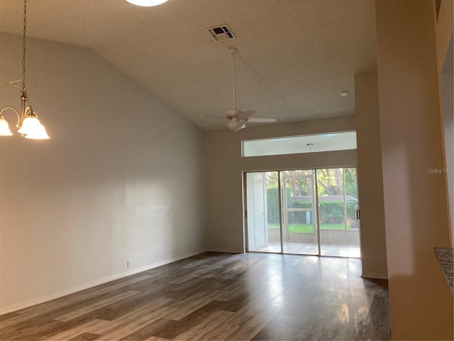 empty room with ceiling fan with notable chandelier, hardwood / wood-style flooring, and high vaulted ceiling