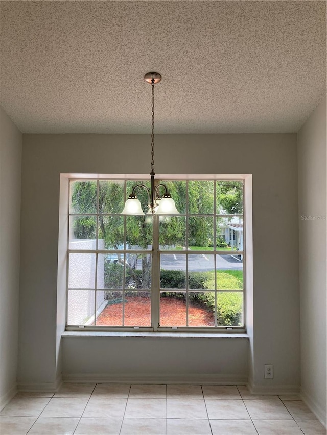 unfurnished dining area featuring a healthy amount of sunlight, a chandelier, and light tile patterned floors