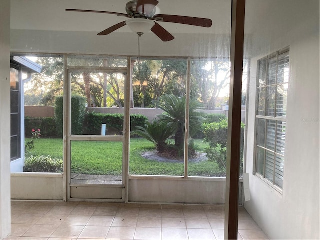 unfurnished sunroom with ceiling fan