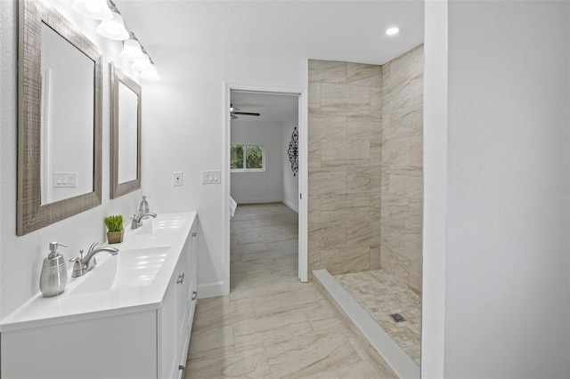 bathroom with tiled shower and vanity