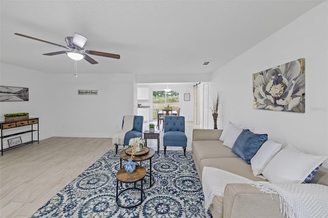 living room featuring ceiling fan and light wood-type flooring