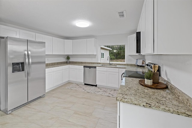 kitchen featuring stainless steel appliances, light stone countertops, sink, and white cabinets