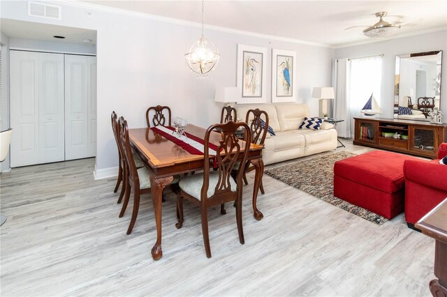 dining room featuring ornamental molding, light hardwood / wood-style flooring, and a notable chandelier