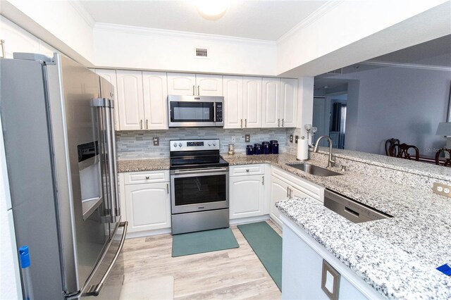 kitchen featuring crown molding, appliances with stainless steel finishes, sink, and white cabinets