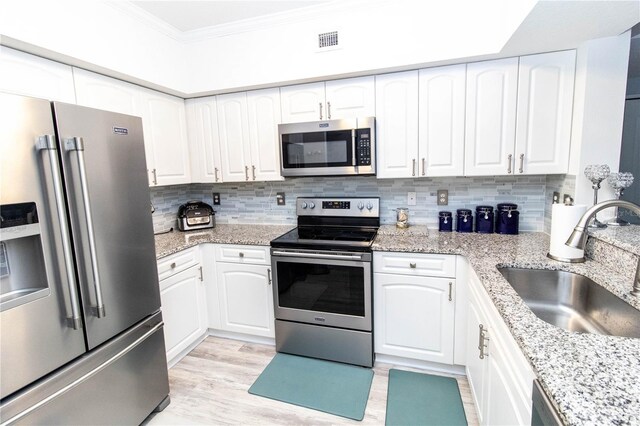 kitchen with sink, white cabinets, and appliances with stainless steel finishes