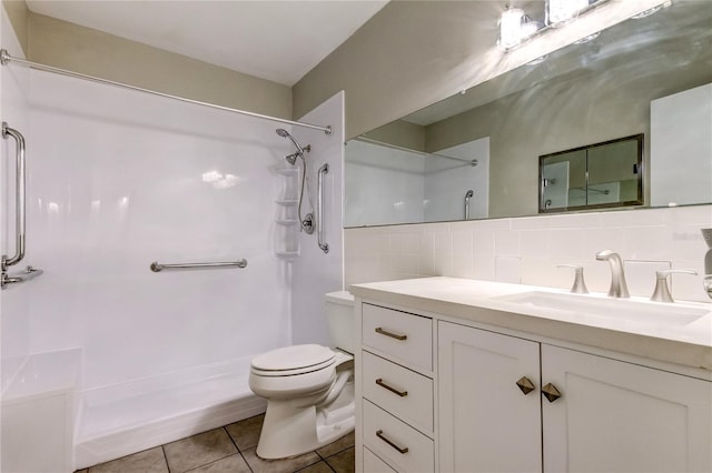 bathroom with tasteful backsplash, vanity, a shower, tile patterned floors, and toilet