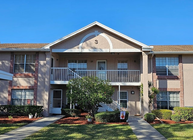 exterior space featuring a balcony and a front lawn