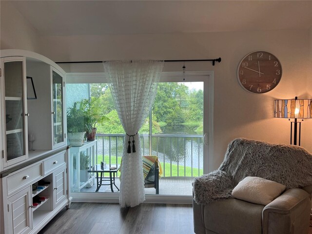 doorway to outside with dark wood-type flooring and a water view