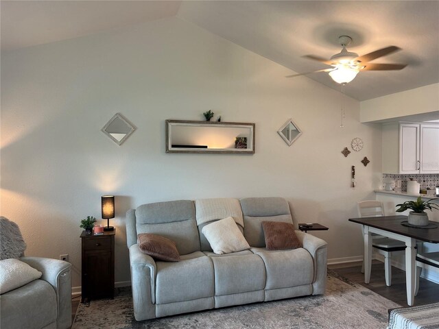 living room featuring wood-type flooring, ceiling fan, and vaulted ceiling